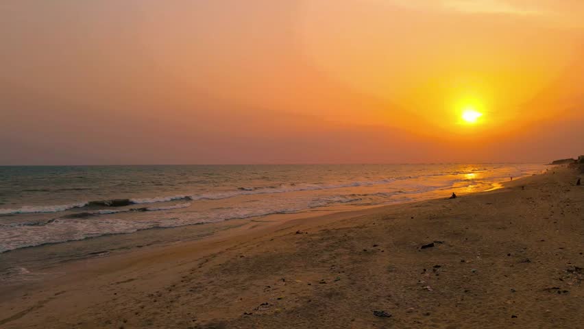 Yellowish beem of sun set light at the beach with sea waves dancing majestically 