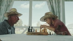 Grandfather and grandson play chess on the veranda at home - Powered by Shutterstock - Get 15% off with code: PIKWIZARD15