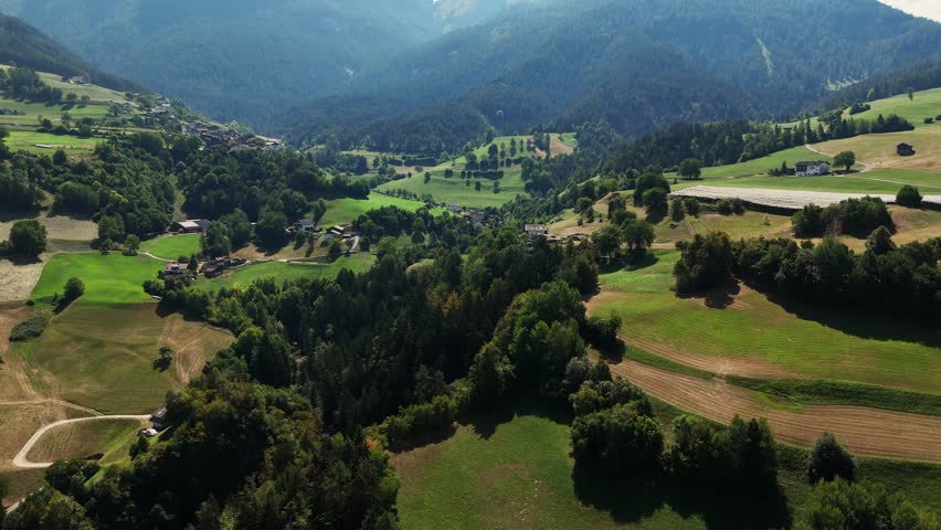 Camera panning over beautiful green valley with houses