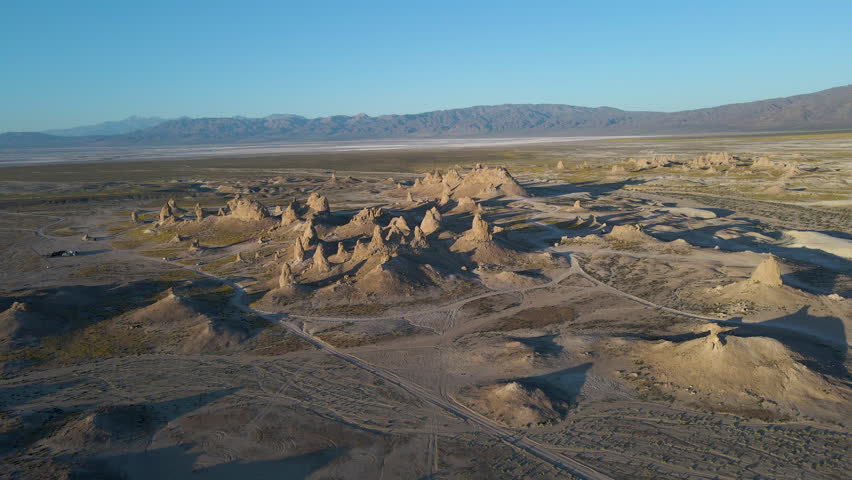 Cinematic aerial shot of wildflower super bloom covering Trona Pinnacles at sunrise in Mojave Desert in California, USA