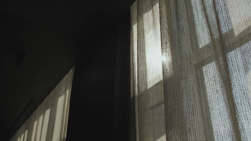 Soft and gentle light filtering through sheer curtains in a beautifully dimly lit room