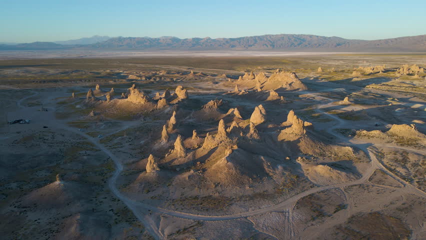 Cinematic aerial shot of wildflower super bloom covering Trona Pinnacles at sunrise in Mojave Desert in California, USA