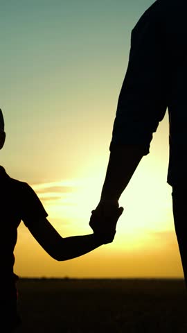 Little son, dad hold hands close-up in nature in sun. Child father walk in park at sunset. Dad, son. Parent, kid boy outing together. Happy family, teamwork. Family trust concept. Silhouette child