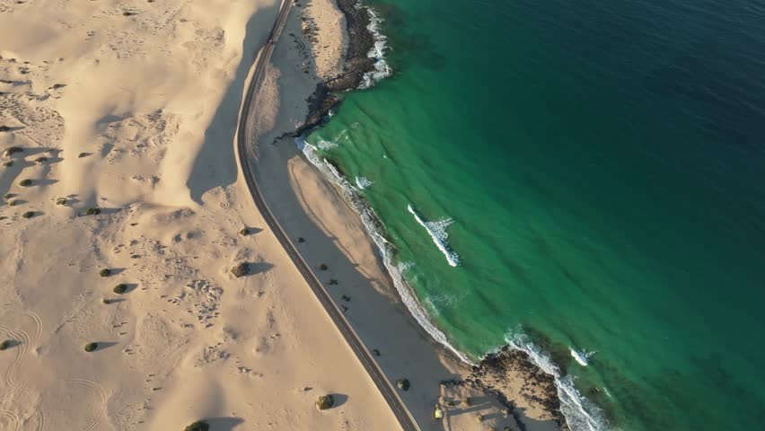 Aerial view of beautiful sand dunes and tranquil ocean with a scenic shoreline, Parque Natural de Corralejo, Fuerteventura, Spain.