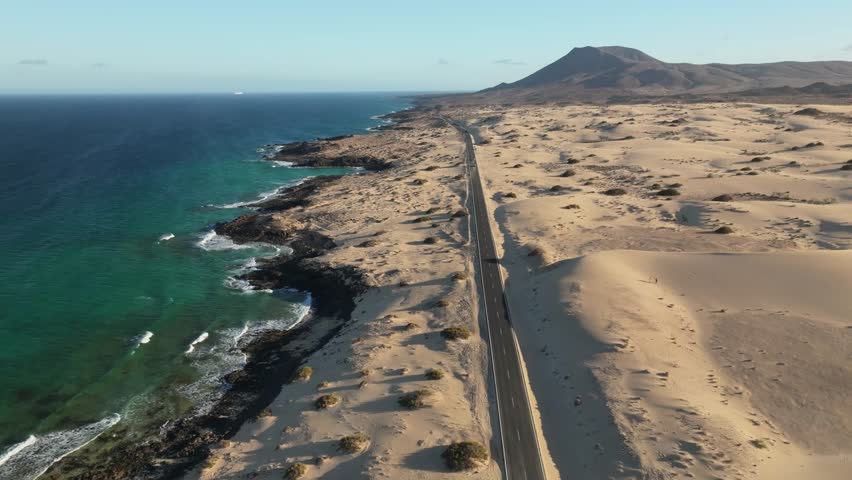 Aerial view of beautiful sand dunes and coastline with ocean at sunset, Parque Natural de Corralejo, Fuerteventura, Canary Islands, Spain.