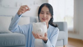 Young Asian woman putting coin in piggy bank. Save money and financial investment - Powered by Shutterstock - Get 15% off with code: PIKWIZARD15