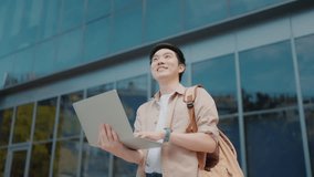Portrait of handsome Asian student using computer laptop. A young man standing outdoor happy smiling - Powered by Shutterstock - Get 15% off with code: PIKWIZARD15