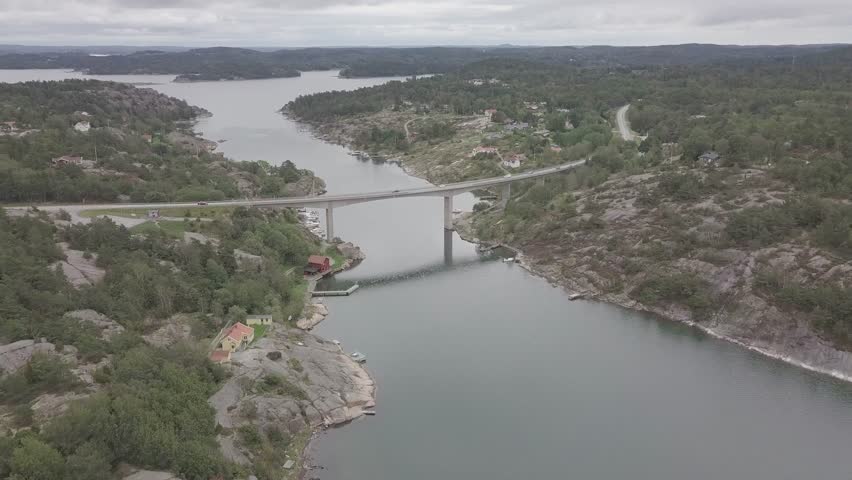 Aerial view of Varekilsnas Bridge over a scenic river surrounded by beautiful forest and hills, Varekilsnas, Sweden.