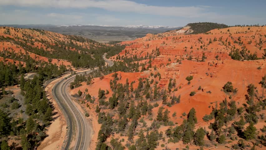 Aerial view of red canyon with winding road and majestic rock formations, Bryce Canyon City, United States.