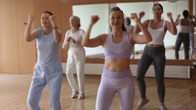 Active young woman practicing aerobic dance in training hall during fitness dance classes. Women training dance in hall - Powered by Shutterstock - Get 15% off with code: PIKWIZARD15