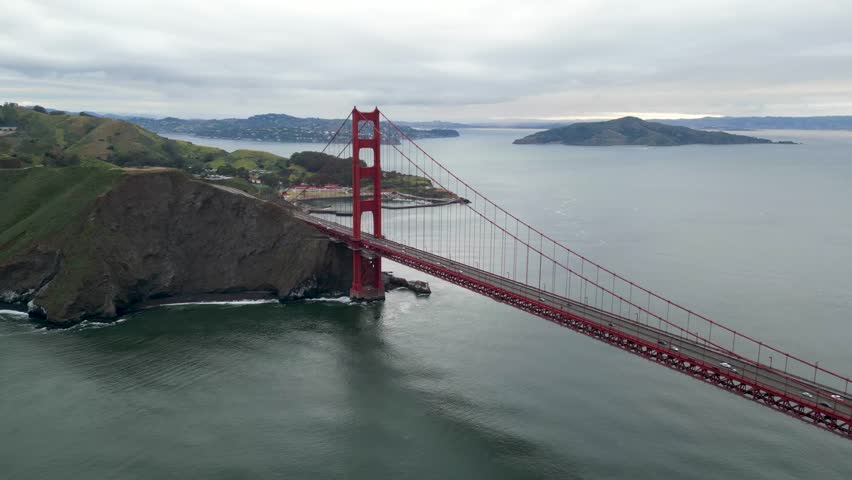 Aerial view of the iconic golden gate bridge spanning a scenic bay under a cloudy sky, San Francisco, United States.