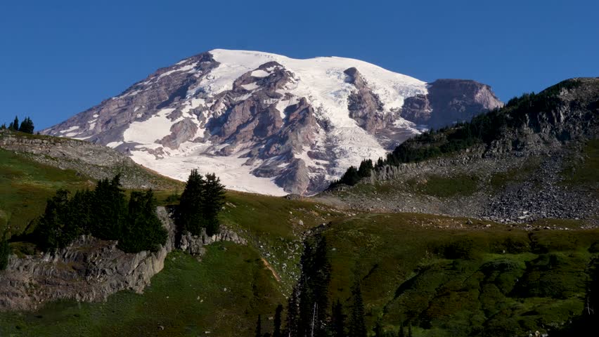 Drone aerial landscape of Mount Rainier Tahoma stratovolcano snow cap mountain summit grassy meadows park Washington state Seattle hiking travel tourism USA America