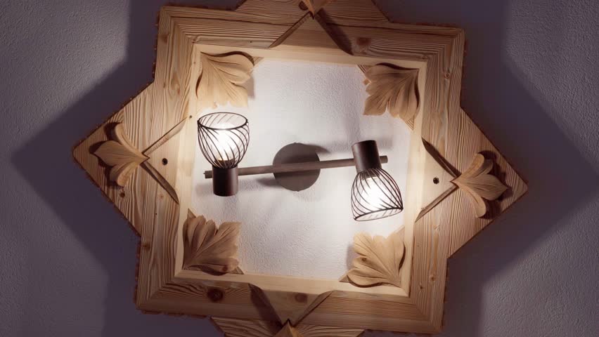 Spinning shot of an indoor self-made desing ceiling-light made out of wood, lights turned on