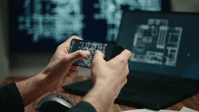 The video shows male hands holding a smartphone and working on a laptop with building plans or blueprints displayed on the screens. The architect is working on a project. - Powered by Shutterstock - Get 15% off with code: PIKWIZARD15