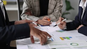 Financial analysts strategizing on charts and data during a meeting. Financial analysts discuss charts and graphs, using calculator to analyze data during a business meeting. - Powered by Shutterstock - Get 15% off with code: PIKWIZARD15
