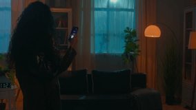 Smart home lighting system innovation technology power lamp woman walking in dark distant turning lightness electricity modern futuristic house night female girl use mobile phone turn light on control - Powered by Shutterstock - Get 15% off with code: PIKWIZARD15