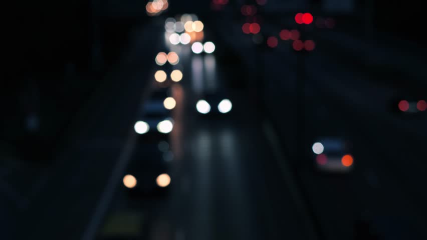 Real time driving cars on a german motorway, out of focus rush hour at night. Moving red and white light dots on a multi-lane road near Munich, Germany. There is an omnibus in the scene as well.