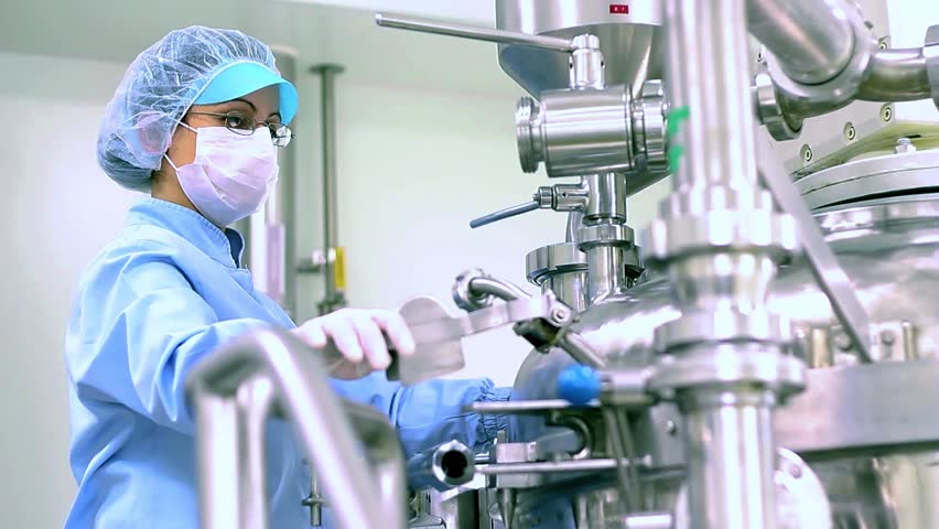 Pharmaceutical Industry Technician in Protective Workwear Works in Sterile Environment. Pharmaceutical Research And Development Of New Medicines. Clean Room in Pharmaceutical Industry.