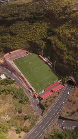 Aerial view of Estadio Silvestre Carrillo surrounded by a beautiful green field and scenic mountains, Santa Cruz de La Palma, Spain.