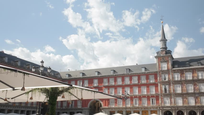left to right pan revealing shot of Plaza Mayor Square buildings in Madrid, Spain on a sunny summer day with tourist walking and enjoying the city