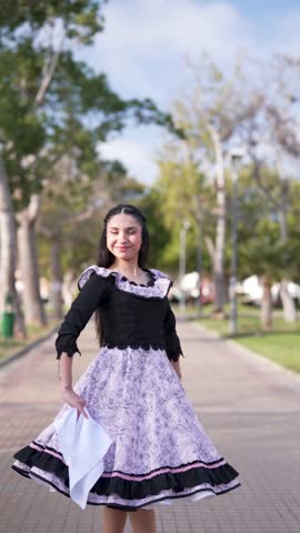 Young woman dressed as a Chilean huasa posing doing cueca steps, Fiestas Patrias concept 