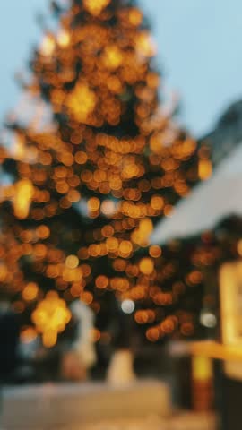 A blurred Christmas tree with colorful lights creates a warm, festive atmosphere