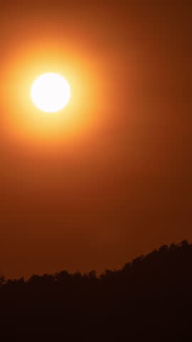 Timelapse of dramatic sunset with orange sky in a sunny day.