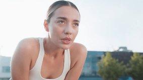 Tired young athlete woman resting after hard training in urban city park. Determined sportswoman jogger takes deep breath looking away. Catching breath, reflects on progress and plans next workout. - Powered by Shutterstock - Get 15% off with code: PIKWIZARD15