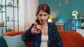 Furious young Caucasian woman sitting on sofa couch at home, angrily pointing at you through the camera, displeased and fuming. Young adult girl in serious blame mode, upset, and ready to explode. - Powered by Shutterstock - Get 15% off with code: PIKWIZARD15