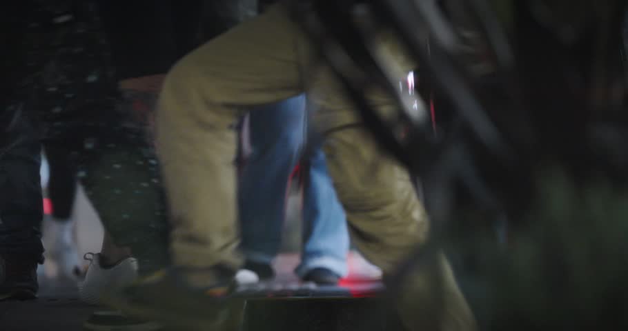 A low-angle look at commuters boarding and exiting a subway car, at night.