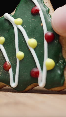 Vertical video. Sprinkling Gold Dust on a Christmas Tree Cookie, Adding a Touch of Magic to the Holiday Treats. Christmas Evening. Slow Motion
