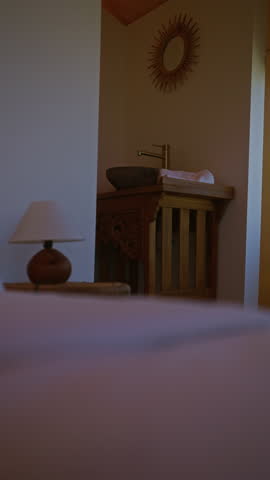 Rustic bathroom with wooden sink, mirror, and lamp in a cozy, intimate setting highlighting a traditional design.