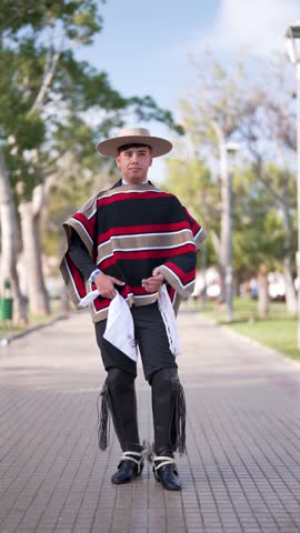 Young male dressed as a Chilean huaso posing doing cueca steps, Fiestas Patrias concept