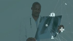 Animation of network of connections with icons over biracial male doctor holding xray. Technology, medicine and digital interface concept digitally generated video. - Powered by Shutterstock - Get 15% off with code: PIKWIZARD15