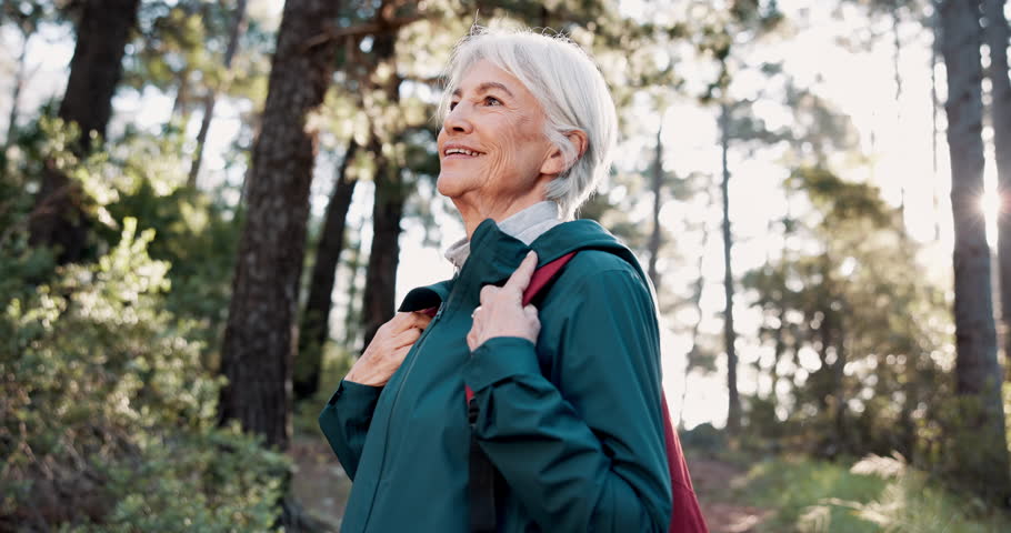 Face, forest and senior woman hiking for travel, holiday or vacation outdoor. Portrait, smile and person trekking in woods for adventure, journey and retirement hobby to explore Canada for tourism
