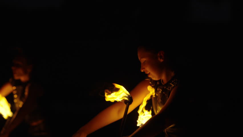 Young Women Performing Fire Show, Female Dancers Moving In Darkness With Flashes Of Fire