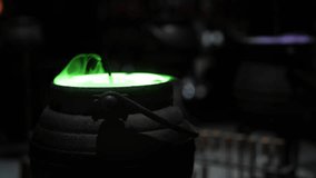 Magic cauldron with mysterious potion and green smoke light from a vintage black pot when wizard cooking and mix dark spell in the fantasy magician for Spooky Halloween - Powered by Shutterstock - Get 15% off with code: PIKWIZARD15