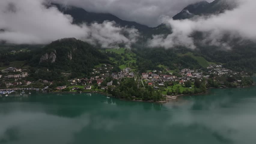 The darkened Lake Walensee with the village of Weesen on the shore from a drone view, Switzerland