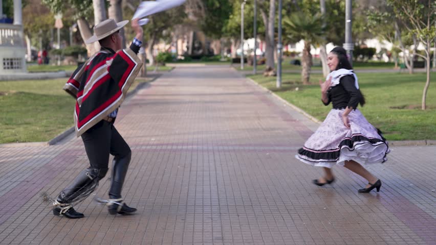 couple of huasos dancing Chilean cueca in the city square, Fiestas Patrias concept