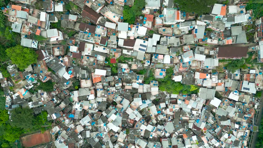 Aerial view of a dense residential area adjacent to lush green forest in Rio de Janeiro.