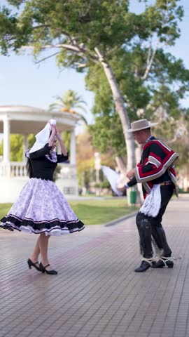 couple of huasos dancing Chilean cueca in the city square, Fiestas Patrias concept