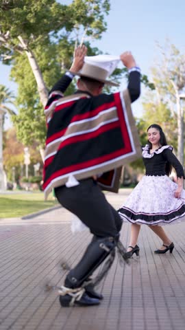 couple of huasos dancing Chilean cueca in the city square, Fiestas Patrias concept
