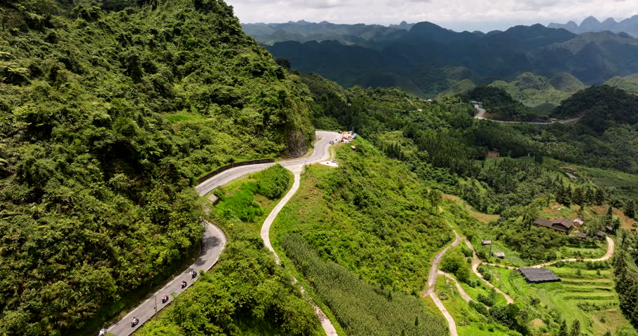 Motorbikes driving along Quan Ba Pass, Ha Giang Loop, Vietnam in Asia. Aerial drone panoramic view