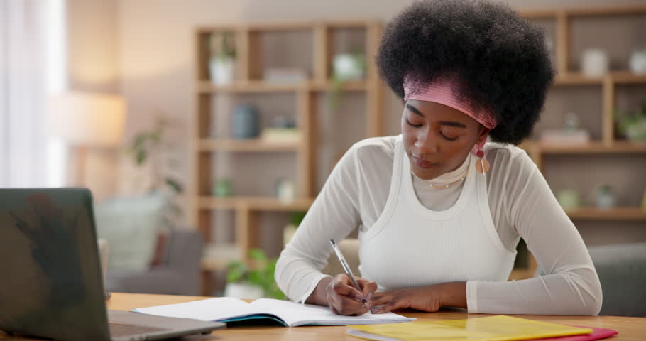 Girl, writing and e learning with laptop, notebook and assignment for scholarship or research in home. Black woman, technology and notes with studying for development, education or support as student