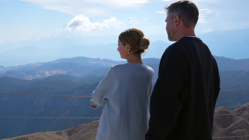 Man and woman enjoy sunset in the mountains