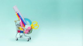 Shopping cart with school supplies on blue background. Preparing for school, buying stationery concept. Stop motion animation banner copy space minimal - Powered by Shutterstock - Get 15% off with code: PIKWIZARD15