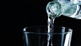 closeup of pouring drinking water from a glass bottle into a water glass isolated on black background, motion design overlay texture template - Powered by Shutterstock - Get 15% off with code: PIKWIZARD15