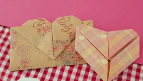 Two heart-shaped origami designs on pink and checkered backgrounds, showcasing delicate craftsmanship - Powered by Shutterstock - Get 15% off with code: PIKWIZARD15