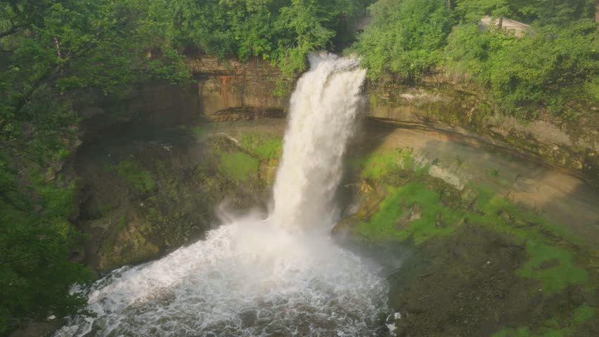 Aerial pan shot of Minnehaha Falls at a forest of Minneapolis in Minnesota, USA.