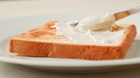 Cream cheese Spreading with knife on toasted bread slice, women hands apply fresh butter cream cheese on a slice of freshly baked bread close up, morning breakfast. - Powered by Shutterstock - Get 15% off with code: PIKWIZARD15